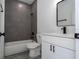 Modern bathroom featuring gray tile, white vanity with quartz countertop and black fixtures at 2580 Gallardia Dr, Lake Wales, FL 33898