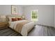 Cozy bedroom with natural light, wood floors, and a serene view of the outdoor landscape at 2580 Gallardia Dr, Lake Wales, FL 33898