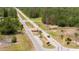 Community entrance with a guard house, U.S. flag, decorative landscaping, and palm trees on a paved road at 2580 Gallardia Dr, Lake Wales, FL 33898