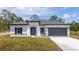 Charming single-story home featuring a gray roof, a gray garage door, and black trim around the white exterior at 2580 Gallardia Dr, Lake Wales, FL 33898