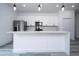 Modern kitchen with white cabinets, a center island, stainless steel appliances, and stylish pendant lighting at 2580 Gallardia Dr, Lake Wales, FL 33898