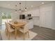 Open-concept kitchen and dining area featuring white cabinets, stainless steel appliances, and pendant lighting at 2580 Gallardia Dr, Lake Wales, FL 33898