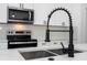 Close-up of a kitchen with a stainless steel sink, modern faucet, and stainless steel appliances at 2580 Gallardia Dr, Lake Wales, FL 33898