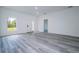 Open living room with gray wood-look floors, large window, and white front door at 2580 Gallardia Dr, Lake Wales, FL 33898
