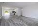 Open-concept living space featuring a kitchen with white cabinets, pendant lights, and hardwood floors at 2580 Gallardia Dr, Lake Wales, FL 33898