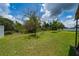 Large backyard with healthy grass, mature trees, and a blue bicycle providing a tranquil outdoor setting at 2726 Harmonia Hammock Rd, Harmony, FL 34773
