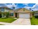 Charming home exterior featuring a well-kept lawn, two-car garage and inviting curb appeal at 2726 Harmonia Hammock Rd, Harmony, FL 34773
