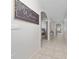 Bright hallway with neutral paint, tile floors, archways and view to other rooms at 2726 Harmonia Hammock Rd, Harmony, FL 34773