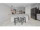 Modern kitchen with an island, breakfast bar, granite countertops, and barstools at 2726 Harmonia Hammock Rd, Harmony, FL 34773