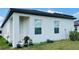 Home's exterior with blue potted plants in green grass, showcasing its tranquil outdoor space at 2860 Poppy Avenue, Haines City, FL 33844