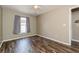 Bright bedroom featuring wood laminate flooring, neutral paint, and a window with gray curtains at 2926 Dickens Cir, Kissimmee, FL 34747