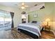 Serene main bedroom with a ceiling fan, wood-look floors, and sliding door access to an outdoor patio at 2926 Dickens Cir, Kissimmee, FL 34747