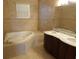 Spa bathroom with tub and dual sinks, featuring neutral tile at 3074 Bay Laurel N Cir, Kissimmee, FL 34744