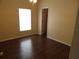 A bedroom with rich wood floors and door leading to another room at 3074 Bay Laurel N Cir, Kissimmee, FL 34744