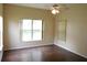 A spacious bedroom with hardwood floors, ceiling fan, and a large window for ample natural light at 3074 Bay Laurel N Cir, Kissimmee, FL 34744
