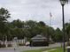Gated community entrance with flag, mature landscaping, and controlled access for enhanced security and curb appeal at 3074 Bay Laurel N Cir, Kissimmee, FL 34744