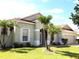 Charming single-story home featuring a well-manicured lawn, a two-car garage, and beautiful palm trees in the front yard at 3074 Bay Laurel N Cir, Kissimmee, FL 34744