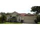 Inviting single-story home featuring a well-maintained lawn, attached two-car garage, and classic architecture at 3074 Bay Laurel N Cir, Kissimmee, FL 34744