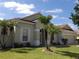 Well-maintained single-story home with a manicured lawn and two mature palm trees in the front yard at 3074 Bay Laurel N Cir, Kissimmee, FL 34744