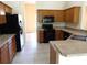 Functional kitchen featuring wooden cabinets and black appliances, providing ample storage and efficient meal preparation space at 3074 Bay Laurel N Cir, Kissimmee, FL 34744