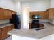 Well-lit kitchen featuring wooden cabinetry and black appliances at 3074 Bay Laurel N Cir, Kissimmee, FL 34744