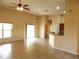 Open-concept living room with lots of natural light, tile flooring, ceiling fan and view into the kitchen at 3074 Bay Laurel N Cir, Kissimmee, FL 34744