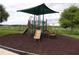 Community playground with covered play structure, slides, and seating on mulch ground at 3074 Bay Laurel N Cir, Kissimmee, FL 34744