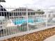 Fenced community pool area with lounge chairs, umbrellas and nearby landscaping at 3074 Bay Laurel N Cir, Kissimmee, FL 34744