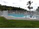 Community pool with surrounding fence, lounge chairs, and manicured lawn at 3074 Bay Laurel N Cir, Kissimmee, FL 34744