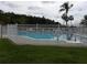 Community pool area surrounded by lush greenery and fencing at 3074 Bay Laurel N Cir, Kissimmee, FL 34744