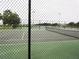 View of community tennis courts for residents, enclosed with dark fencing and manicured landscaping at 3074 Bay Laurel N Cir, Kissimmee, FL 34744