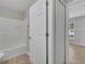 Bathroom with tiled shower-tub combo and adjacent bedroom doorway at 3274 Hunters Chase Loop, Kissimmee, FL 34743