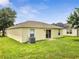 A property with light yellow paint, a well-maintained lawn and an AC unit outside at 3274 Hunters Chase Loop, Kissimmee, FL 34743