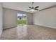 A living room featuring neutral paint, tile flooring, a ceiling fan and sliding glass doors leading to the backyard at 3274 Hunters Chase Loop, Kissimmee, FL 34743
