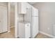 A pantry area with white cabinets and a granite countertop is located near the full-size refrigerator at 3274 Hunters Chase Loop, Kissimmee, FL 34743