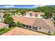 An aerial view shows the community homes with attached garages, mature trees, and manicured lawns on a sunny day at 3428 Village Green Ct, St Cloud, FL 34772