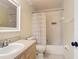 Well-lit bathroom with a combined tub and shower with patterned shower curtain and neutral color scheme at 3428 Village Green Ct, St Cloud, FL 34772