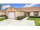 A well-maintained single-story home features an attached garage and manicured hedges at 3428 Village Green Ct, St Cloud, FL 34772