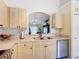 A bright kitchen features stainless steel appliances, light wood cabinets, and a pass-through window at 3428 Village Green Ct, St Cloud, FL 34772