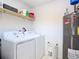 Functional laundry room equipped with modern washer and dryer units and a shelf for storage at 3428 Village Green Ct, St Cloud, FL 34772