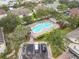 Aerial view of a community pool and parking lot surrounded by lush landscaping and well-maintained homes at 3603 Sanctuary Dr, St Cloud, FL 34769