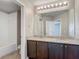 Bathroom featuring dual sinks, granite countertops, dark cabinetry, and lots of mirror space at 3603 Sanctuary Dr, St Cloud, FL 34769