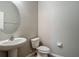 Cozy powder room showcases pedestal sink and a modern round mirror at 3603 Sanctuary Dr, St Cloud, FL 34769
