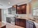 Modern kitchen features dark wood cabinets, granite countertops, and stainless steel appliances at 3603 Sanctuary Dr, St Cloud, FL 34769