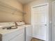 Functional laundry room with washer, dryer, and wire shelving at 3603 Sanctuary Dr, St Cloud, FL 34769