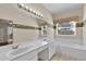 Bathroom featuring double sinks, a large mirror, and a soaking tub at 4065 Kingsley St, Clermont, FL 34711