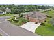 Aerial view of the landscaped single Gathering home on a corner lot with mature trees and a two-car garage at 4065 Kingsley St, Clermont, FL 34711