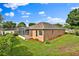 Backyard view of a well-maintained single-story home with a screened-in lanai, manicured lawn, and neat landscaping at 4065 Kingsley St, Clermont, FL 34711