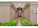 Front door with red door, side lights and transom window with an arched ceiling and decorative plants at 4065 Kingsley St, Clermont, FL 34711