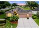 Beautiful front exterior showcasing a three-car garage, landscaped garden, and elegant entrance with sunset lighting at 4065 Kingsley St, Clermont, FL 34711